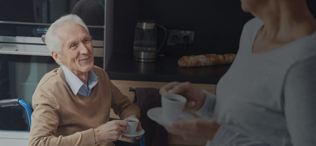 Old man sitting in the kitchen drinking a espresso coffee