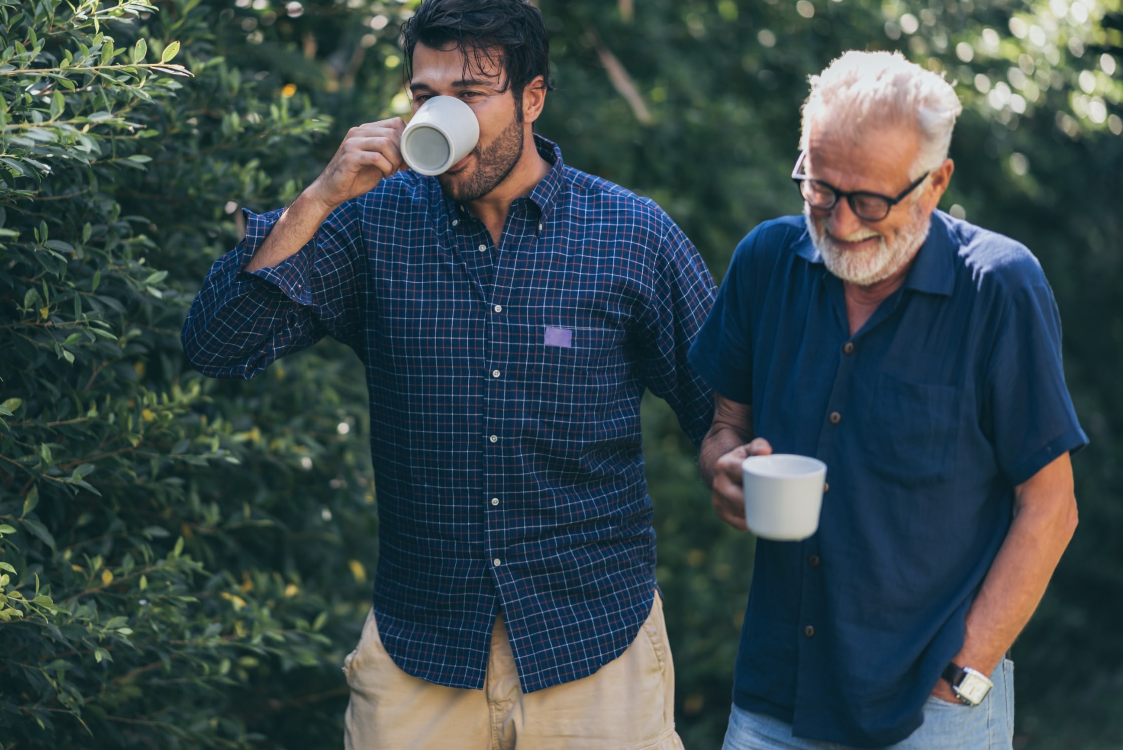 Father and son drinking coffee while walking