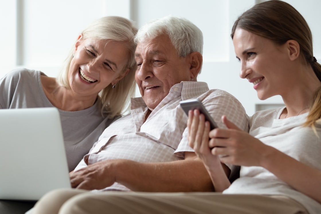 Elderly husband and wife with daughter looking at a website