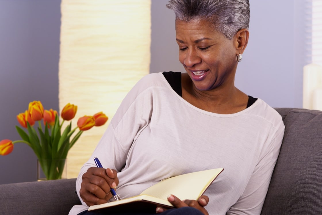 Female writing notes on a notebook.