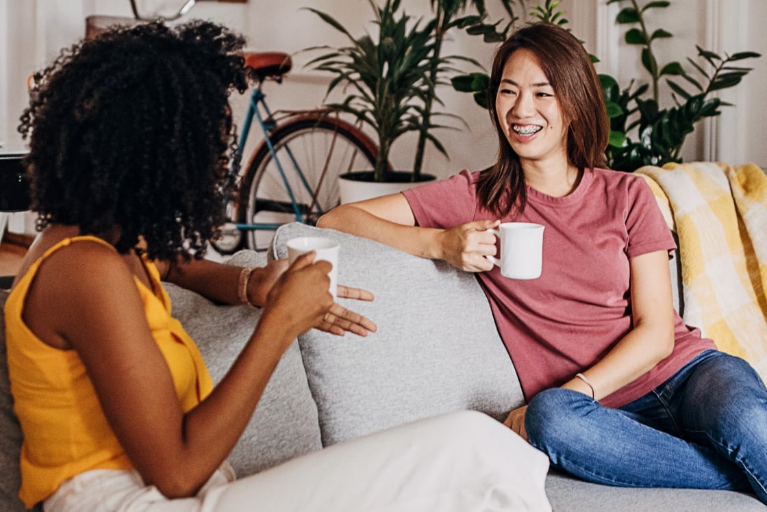 Two women on a sofa drinking tea